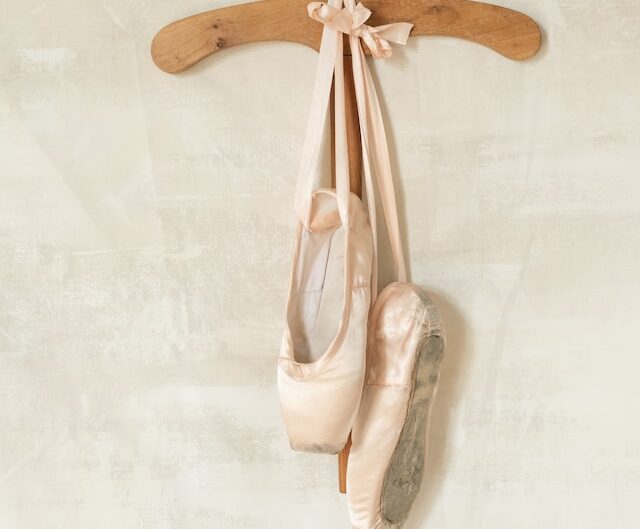 ballet pointe shoes hung up on a hanger